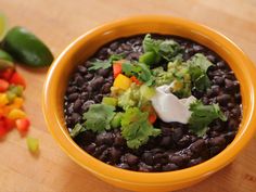 a yellow bowl filled with black beans and guacamole