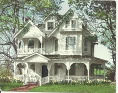 a large white house sitting on top of a lush green field