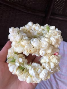 a hand holding a bunch of flowers in it's palm, with the petals still attached