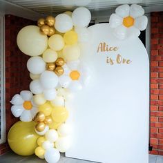 balloons in the shape of flowers and daisies are attached to a white sign that says, alice is one