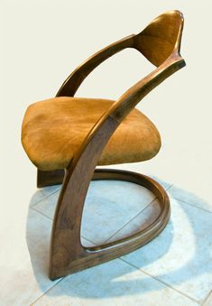 a wooden chair sitting on top of a tile floor next to a white tiled floor