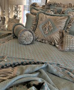 a bed covered in lots of pillows and blankets