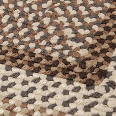 a brown and white rug on top of a wooden floor