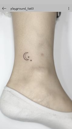 a woman's ankle with a small crescent tattoo on her left side ribcage