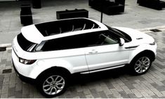 a white range rover parked in front of a building