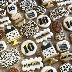 decorated cookies are arranged on a table with the number sixteen written in black and white