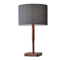 a lamp that is on top of a wooden stand with a gray shade over it