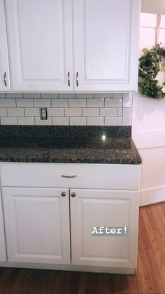 a kitchen with white cabinets and black granite counter tops that has the words after written on it