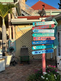 a street sign in front of a building with lots of signs on it's side