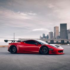 a red sports car parked in front of a city skyline