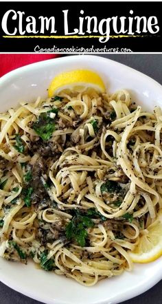 a white plate topped with pasta and lemon wedges