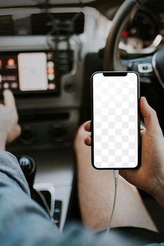 a person holding a cell phone in their hand while sitting in the driver's seat of a car