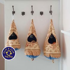 three hanging cat beds in the shape of hammocks with blue bottoms and brown floral print