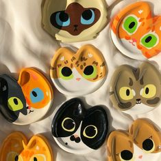 a bunch of plates that have different colored cats on them, one is black and the other is orange