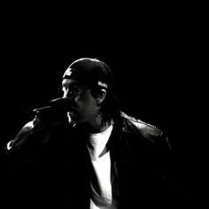 a black and white photo of a man singing into a microphone