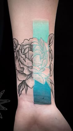 a person with a tattoo on their arm and the wrist has a flower tattooed on it