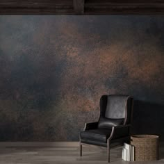 a black chair sitting in front of a wall covered in rusted metal foiling