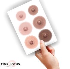 a hand holding up a piece of paper with pink lotus designs on it and six different shades of the same color