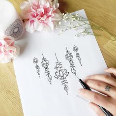 a woman's hand holding a pen over a piece of paper with writing on it