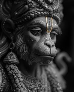 a black and white photo of a statue of a monkey wearing a headdress