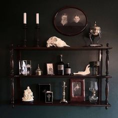 a shelf with candles, pictures and other items on it