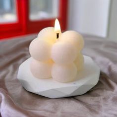 a small white candle sitting on top of a table