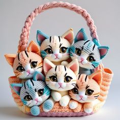 small crocheted kittens sitting in a basket on top of a white surface