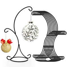 a christmas ornament hanging from a black metal stand next to a gold and silver bauble