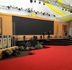 the stage is set up for an event with red carpet and white draping