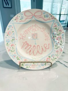 a white plate with pink and blue designs on it that says happy birthday to me