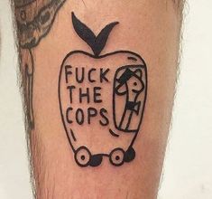 a tattoo on the leg of a man with an apple and words that read f k the cops