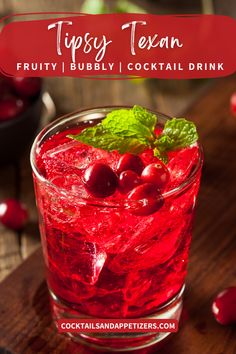 a glass filled with red liquid and cherries