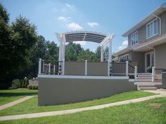 a large house with a covered patio in the front yard and stairs leading up to it