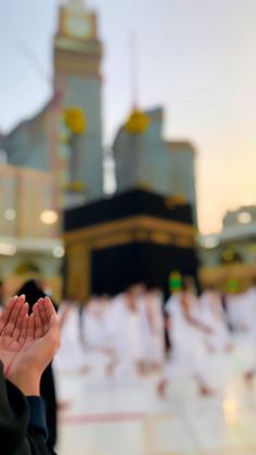 a blurry photo of people praying in front of a building with a clock tower