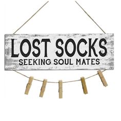 a sign that says lost socks seeking soul mates hanging on a rope with clothes pins