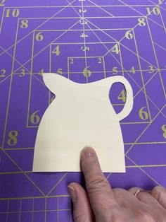 someone is cutting out a paper cutout for a cat ornament with numbers on it