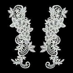 two white laces with flowers and leaves on black background, one in the shape of a