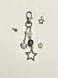 a key chain with charms attached to it on a white surface next to other items