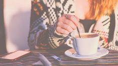 a person sitting at a table with a cup of coffee