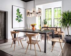 a dining room table with four chairs and a potted plant