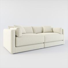 a white couch with pillows sitting on top of it