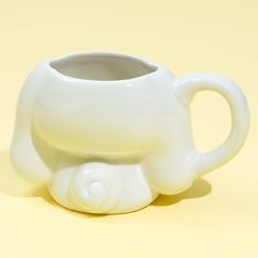 a white ceramic elephant mug sitting on top of a table