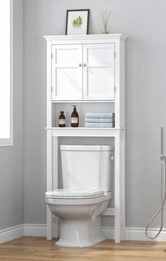 a white toilet sitting in a bathroom next to a shelf with towels on top of it