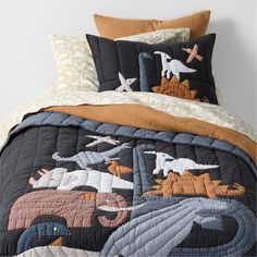 an elephant and giraffe quilt on a bed