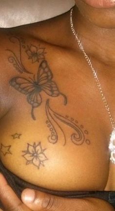 a woman with a butterfly tattoo on her chest is holding something in her right hand