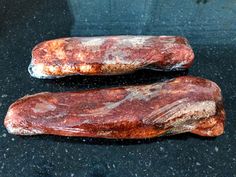 two pieces of meat sitting on top of a counter