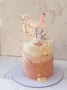 a pink and white cake sitting on top of a table next to a marble wall