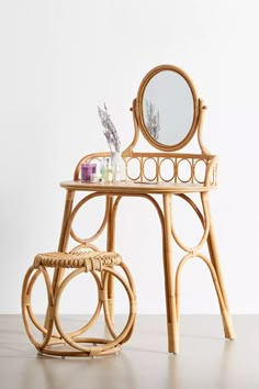 a wooden table with a mirror and some bottles on it next to a wicker stool