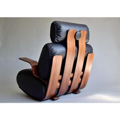 a black leather reclining chair with wood trimmings on the back and sides