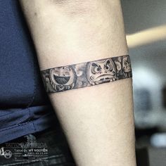 a woman's arm with a tattoo on it that has three faces in the middle